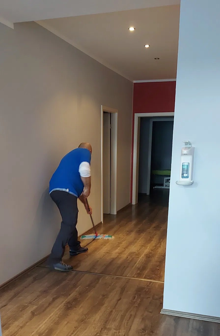 Bodenreinigung mit Wischmopp in einem Praxisflur